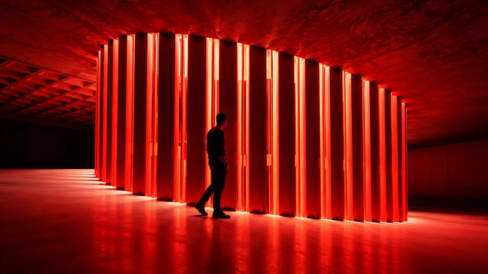 Person walking through a corridor of red vertical lights